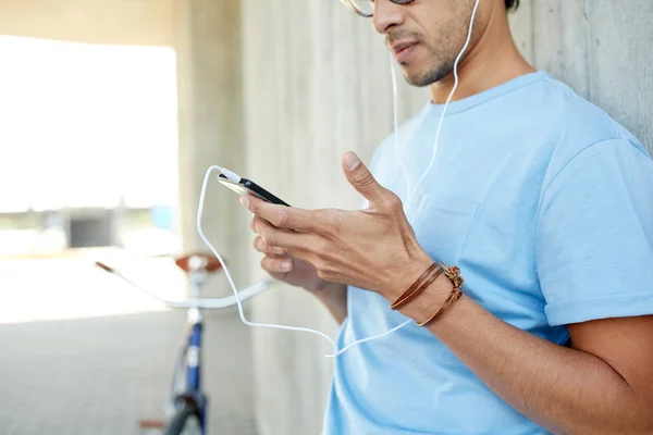 Homem com fones de ouvido e smartphone ouvindo música — Fotografia de Stock