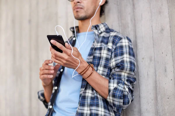 Man med hörlurar och smartphone lyssnar musik — Stockfoto