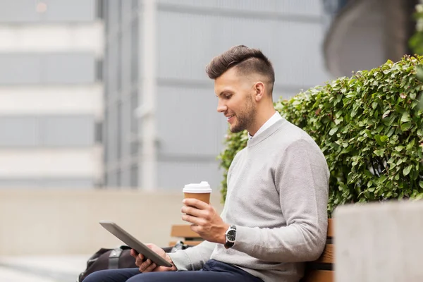 Мужчина с планшетным компьютером и кофе на городской уличной скамейке — стоковое фото