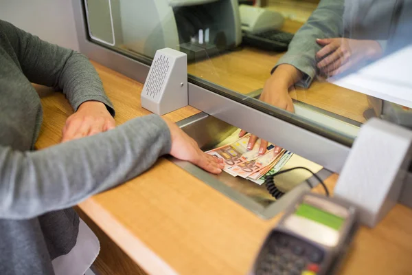 Verkäuferin gibt Kunden in Bankfiliale Bargeld — Stockfoto