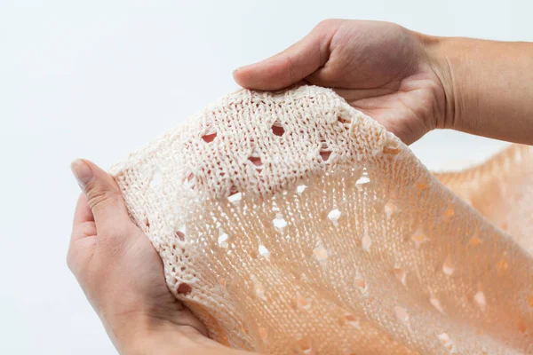 Close up of hands with knitted clothing item — Stock Photo, Image