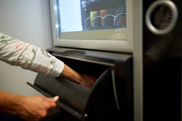 Hand taking purchase from vending machine — Stock Photo, Image