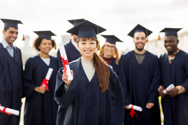 Zadowoleni studenci w moździerzy z dyplomami — Zdjęcie stockowe