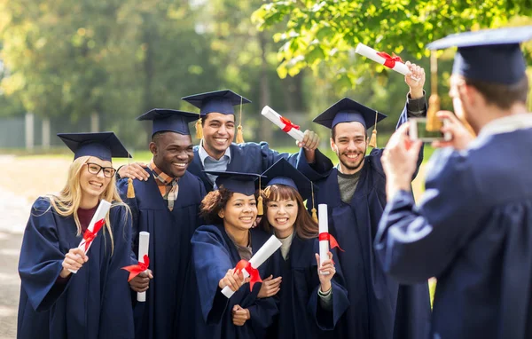 Students or bachelors photographing by smartphone — Stock Photo, Image