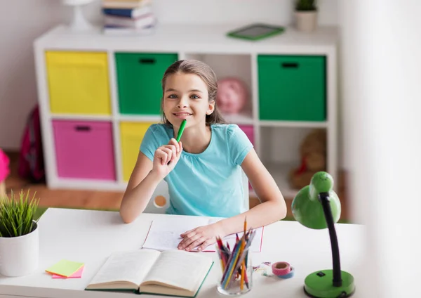 Ragazza felice con libro che scrive a taccuino a casa — Foto Stock