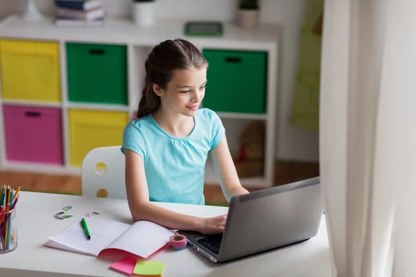 快乐的女孩在家里的笔记本电脑上打字 — 图库照片