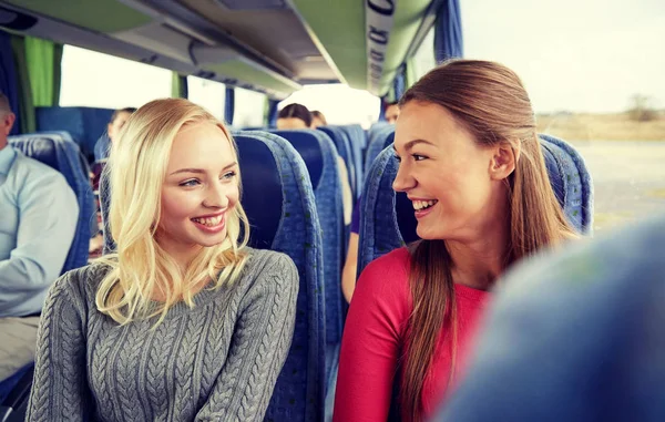 Glade unge kvinder taler i rejse bus - Stock-foto