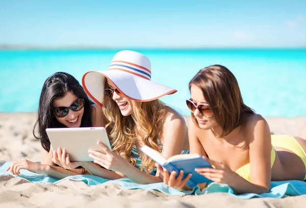 Mujeres con tablet PC y reservar en la playa de verano —  Fotos de Stock