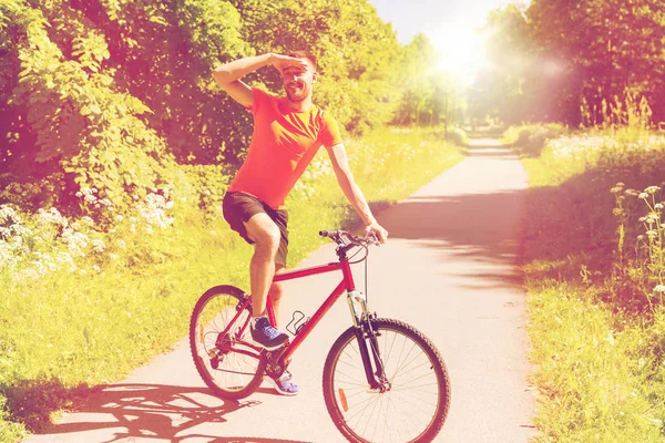 Glücklicher junger Mann, der im Freien Fahrrad fährt — Stockfoto