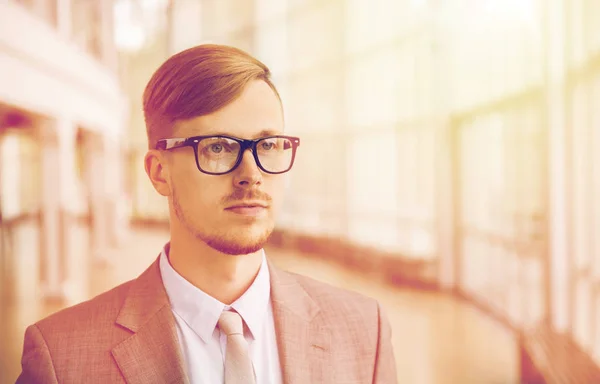 Fiatal üzletember öltönyben és szemüvegben az irodában — Stock Fotó