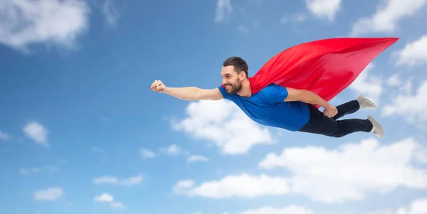 Szczęśliwy człowiek w Przylądek czerwony superbohatera, latające w powietrzu — Zdjęcie stockowe