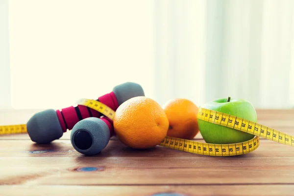 Close up of dumbbell, fruits and measuring tape — Stock Photo, Image