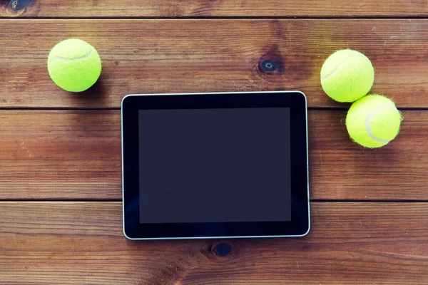 Tenis topları kadar yakın ve tablet pc ahşap üzerine — Stok fotoğraf