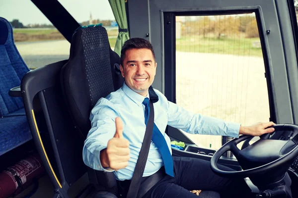 Счастливый водитель за рулем автобуса и заснеженные тумбы — стоковое фото