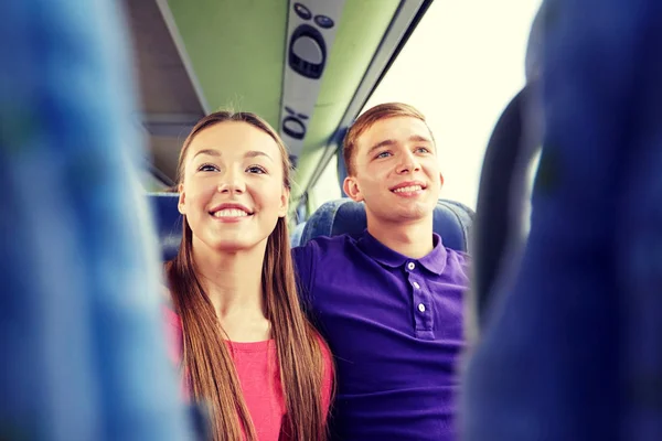 Happy teenage couple or passengers in travel bus — Stock Photo, Image