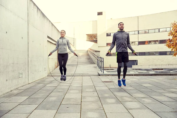 Hombre y mujer haciendo ejercicio con cuerda de salto al aire libre — Foto de Stock