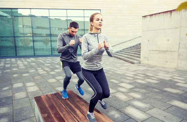 Paar macht Schrittübung auf städtischer Straßenbank — Stockfoto