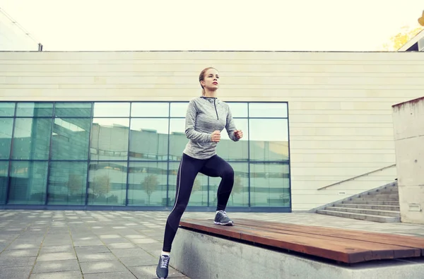 Woman making step exercise on city street bench — Stock Photo, Image