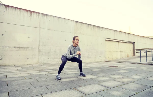 Gelukkige vrouw doen squats en uitoefening van buitenshuis — Stockfoto