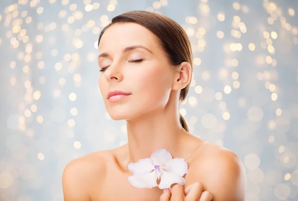 Bela jovem com flor de orquídea — Fotografia de Stock