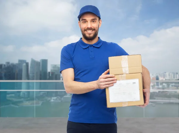 Счастливый доставщик с коробками над городом Сингапур — стоковое фото