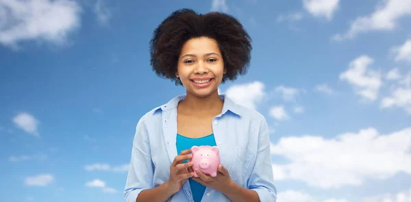 Feliz afro americano jovem mulher com porquinho banco — Fotografia de Stock