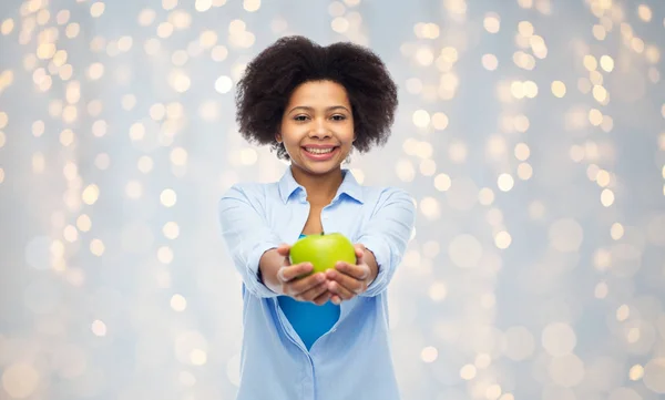 Happy african american woman with green apple — Stock Photo, Image