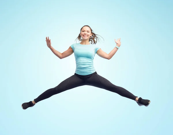 Szczęśliwy uśmiech sportowy młoda kobieta skacze w powietrzu — Zdjęcie stockowe