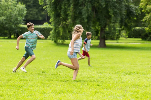 Группа счастливых детей или друзей, играющих на открытом воздухе — стоковое фото