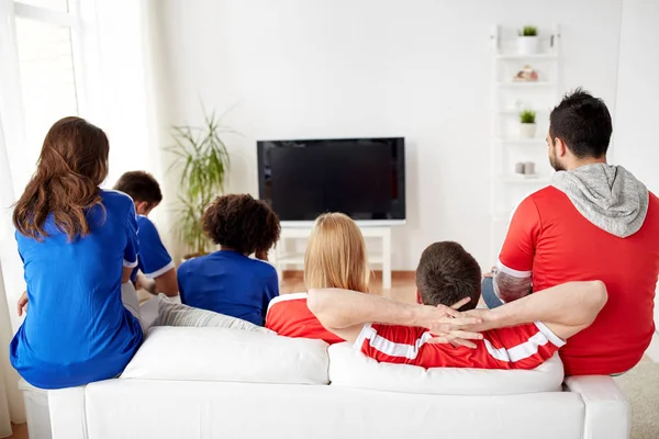 Přátelé nebo fotbaloví fanoušci doma dívat na televizi — Stock fotografie