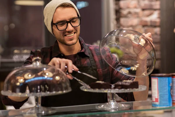 Man of barman met cakes en Tang aan café de balie — Stockfoto