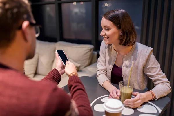 Couple heureux avec smartphone et boissons au café — Photo