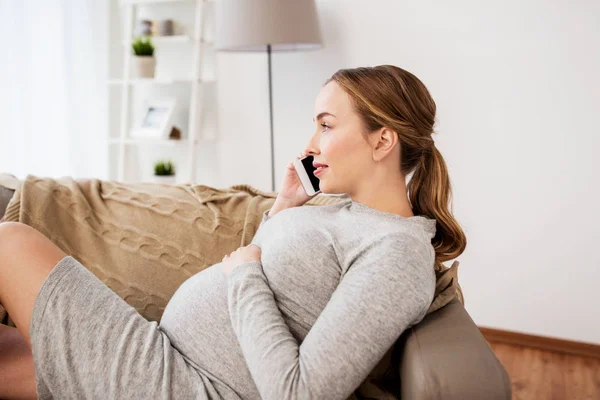 Heureuse femme enceinte appelant sur smartphone à la maison — Photo