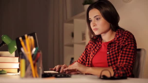 Студентка или женщина, печатающие на ноутбуке ночью дома — стоковое видео