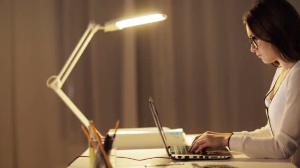 Femme en lunettes tapant sur ordinateur portable au bureau de nuit — Video