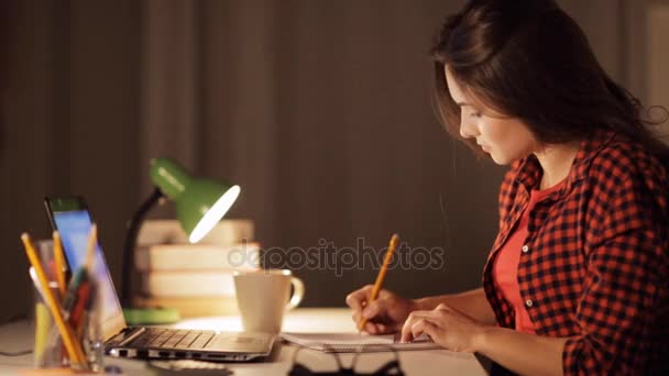 Estudiante chica con cuaderno y calculadora en casa — Vídeo de stock