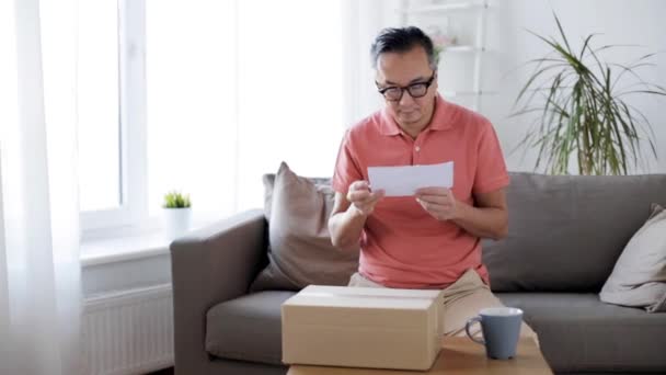 Hombre leyendo factura y caja de apertura en casa — Vídeo de stock