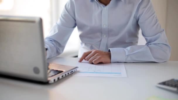 Бизнесмен с ноутбуком и документами в офисе — стоковое видео
