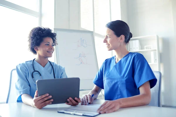 Gelukkig artsen met tablet pc vergadering in ziekenhuis — Stockfoto