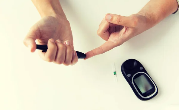 Close up van de vrouw bloedonderzoek door glucometer maken — Stockfoto