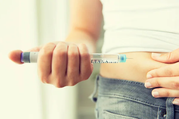 Cerca de las manos haciendo la inyección por la pluma de insulina — Foto de Stock