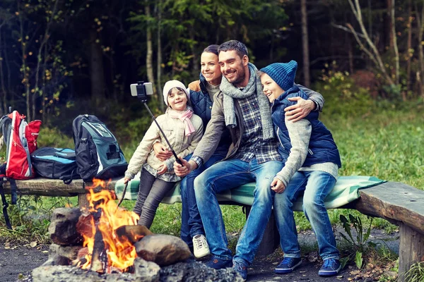 智能手机以自拍照在篝火附近的家庭 — 图库照片