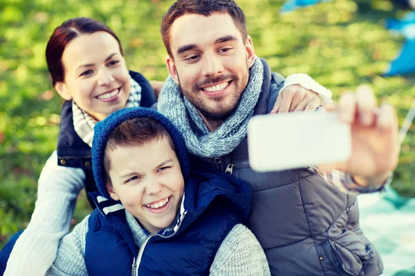 Family with smartphone taking selfie at campsite — Stock Photo, Image