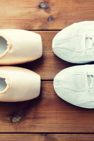 Close up of sneakers and pointe shoes on wood — Stock Photo, Image