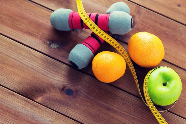 Close up of dumbbell, fruits and measuring tape — Stock Photo, Image