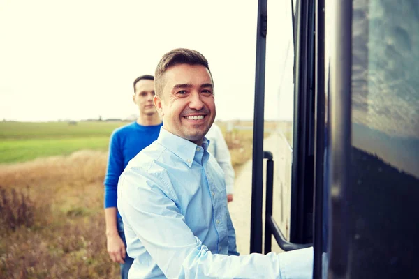 Group of happy male passengers boarding travel bus — Stock Photo, Image