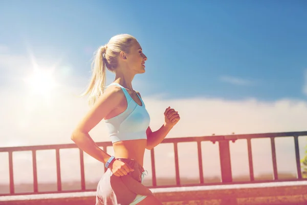 Smiling young woman running outdoors — Stock Photo, Image