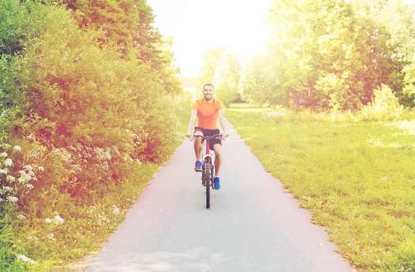 Glücklicher junger Mann, der im Freien Fahrrad fährt — Stockfoto