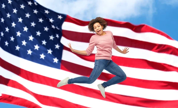 Glückliche Afrikanerin springt über amerikanische Flagge — Stockfoto