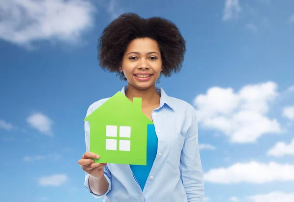 Happy african american woman with green house icon — Stock Photo, Image